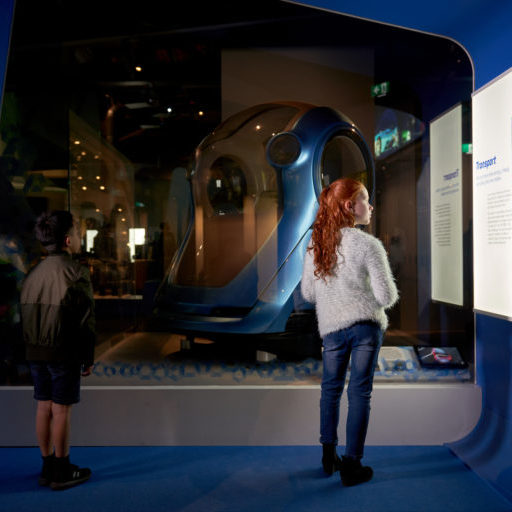 Two kids viewing an exhibit on future transport technology.
